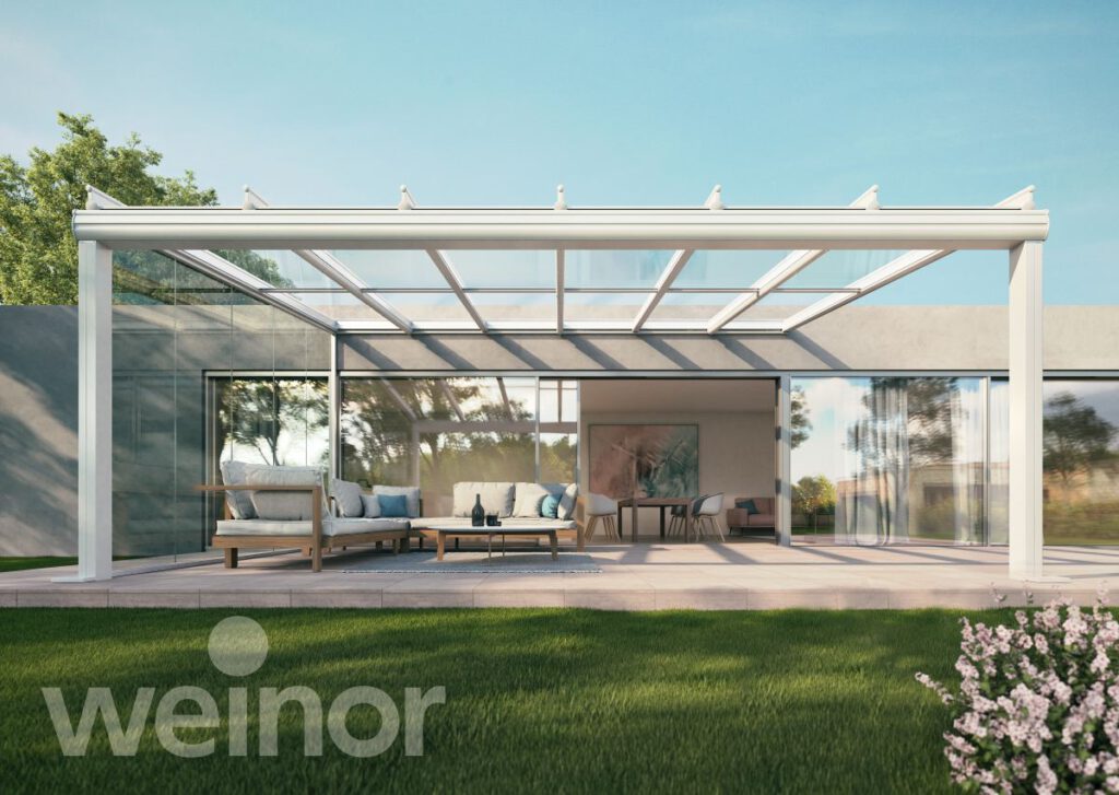 Terrassenüberdachung aus Aluminium mit Glasdach über einer Lounge-Sitzgruppe