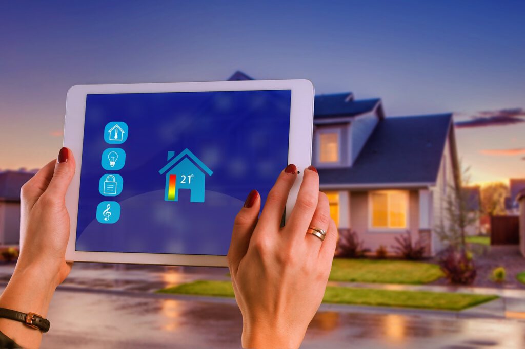 Smart-Home-Steuerung auf einem Tablet vor einem beleuchteten Einfamilienhaus in der Dämmerung